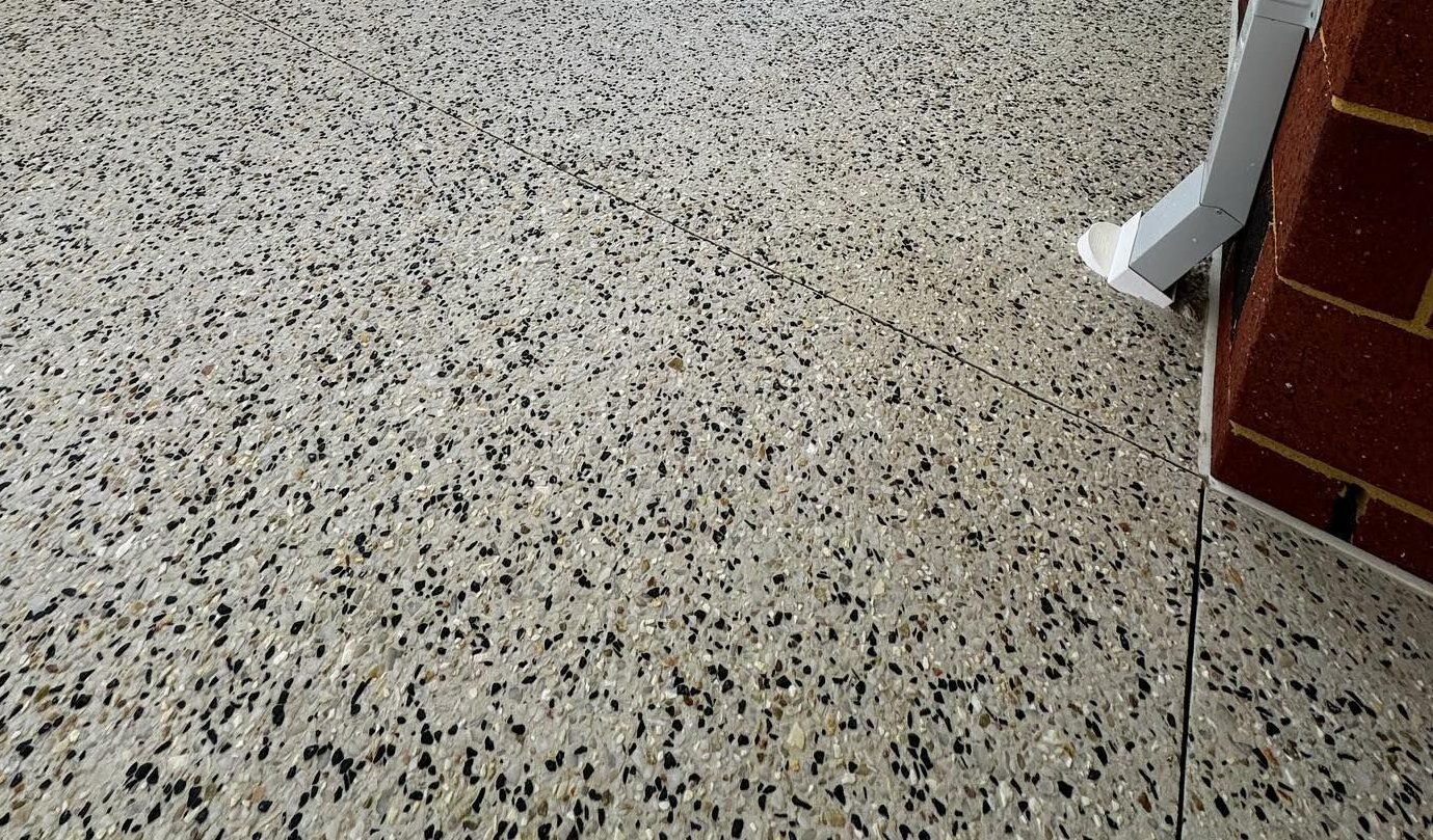 Close up of Kajaani white exposed aggregate concrete poured under patio at Perth home.