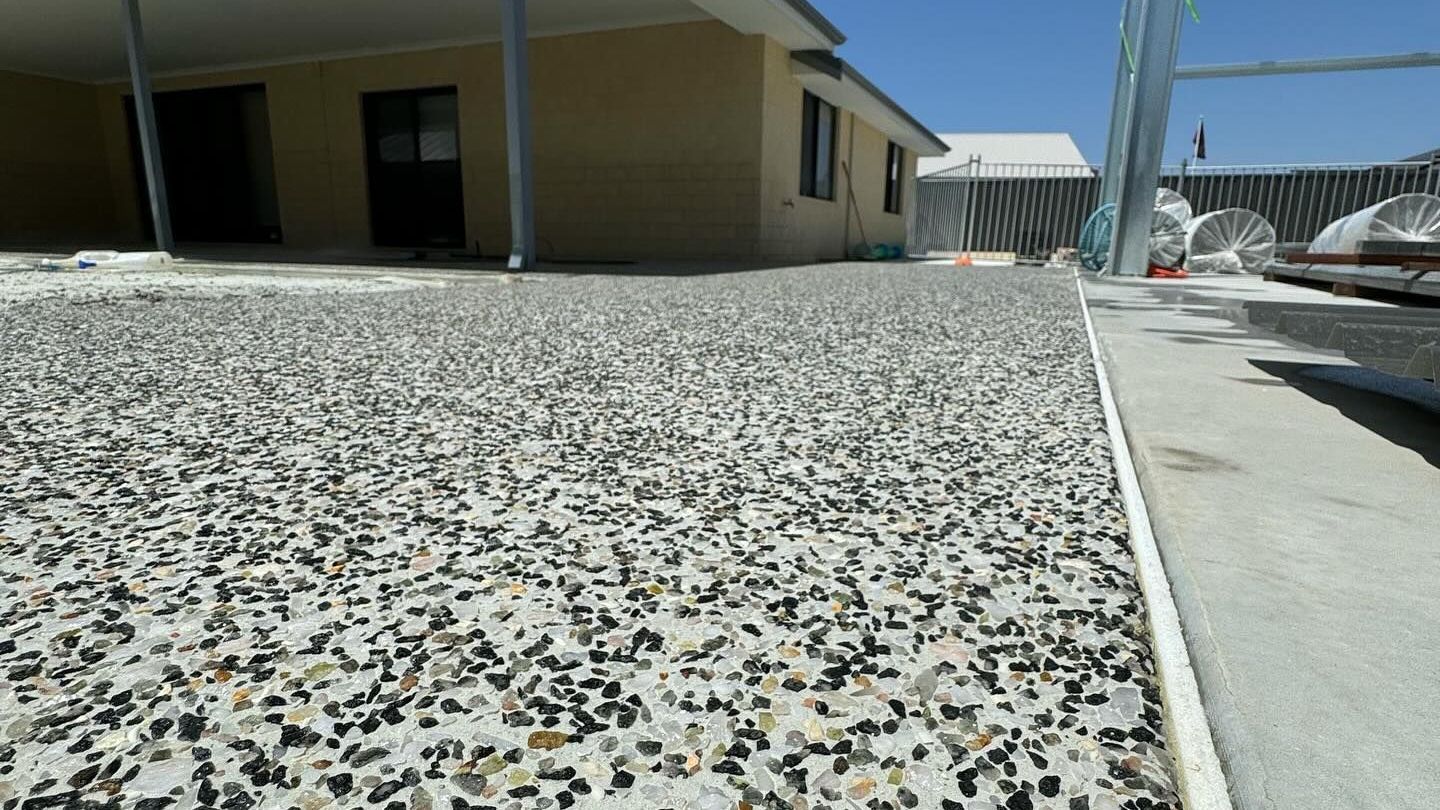 Exposed Aggregate Patio with house and new shed in the background