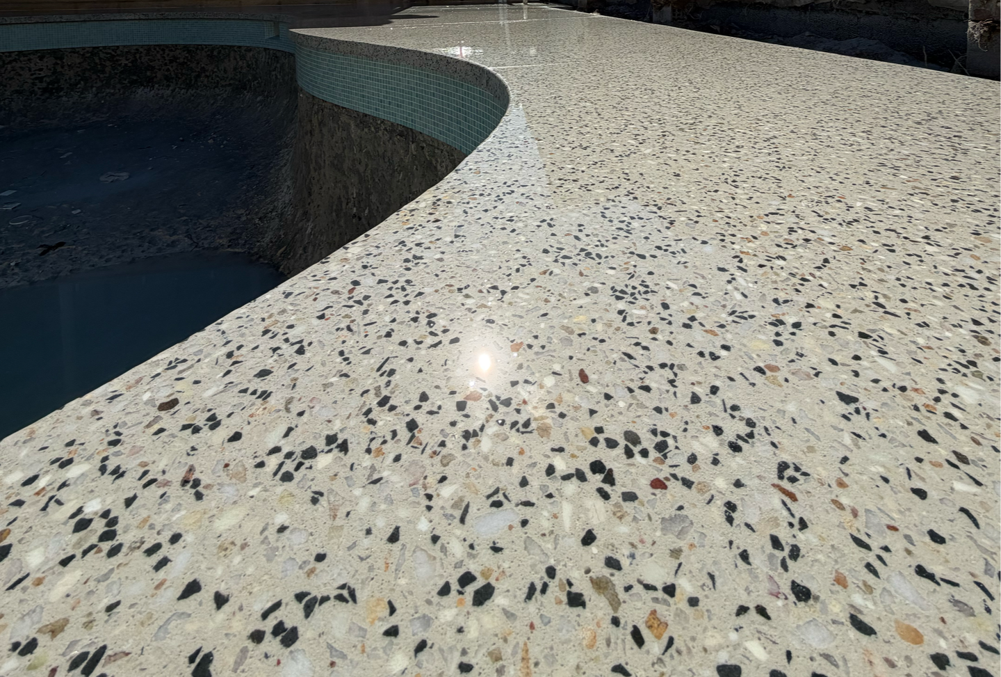 Close up of curved honed aggregate pool surrounds.