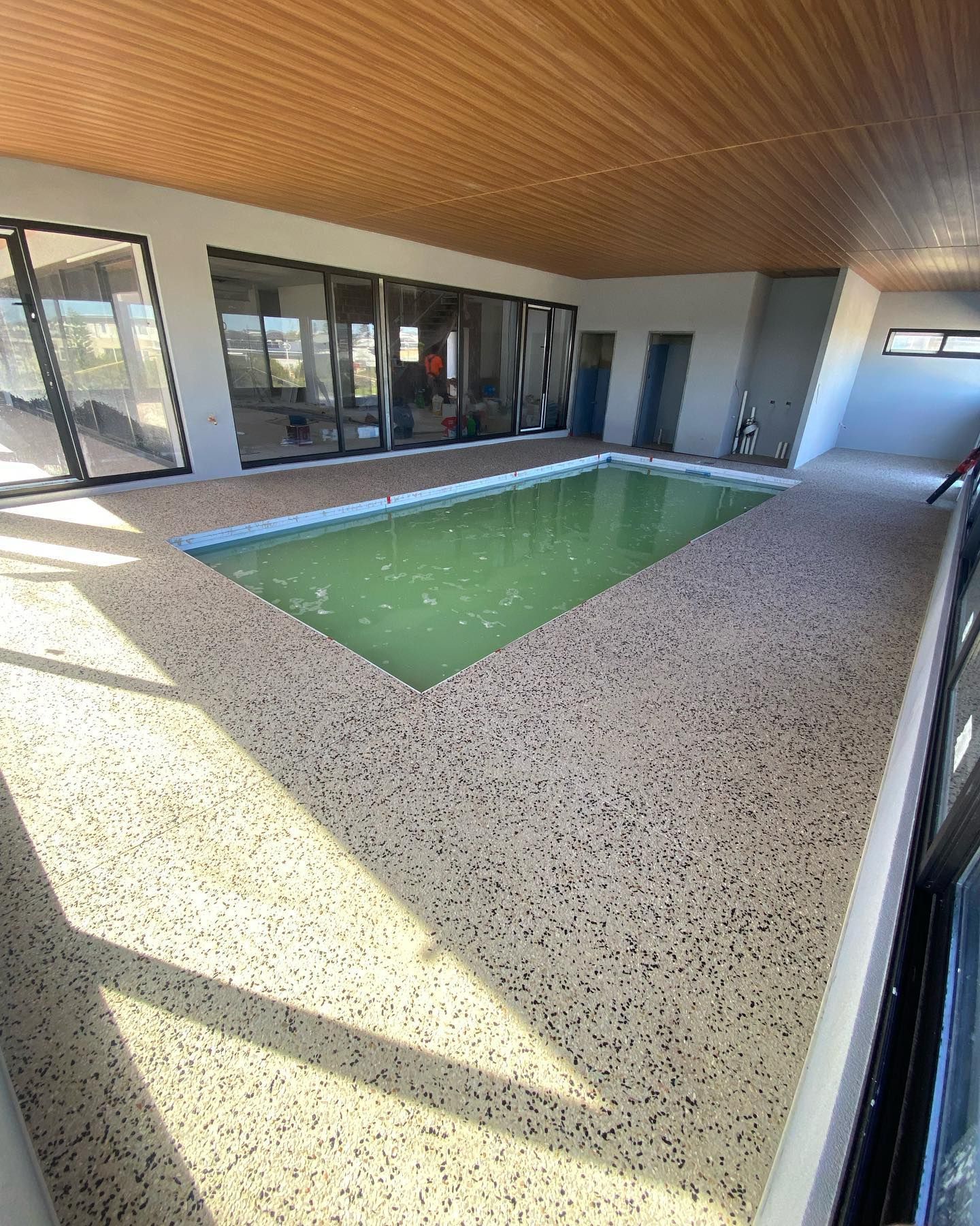 honed aggregate concrete pool surround in under cover area