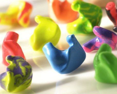 A collection of colorful, custom-molded silicone earplugs in shades of blue, green, yellow, orange, and purple.