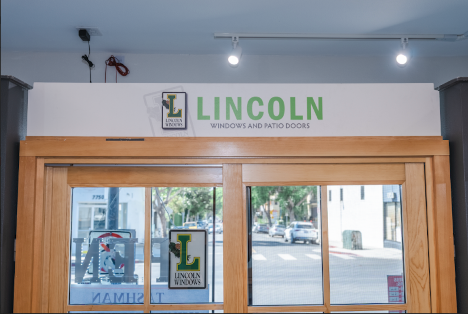 Sign for Lincoln Windows and Patio Doors above an entryway with a view of a street.