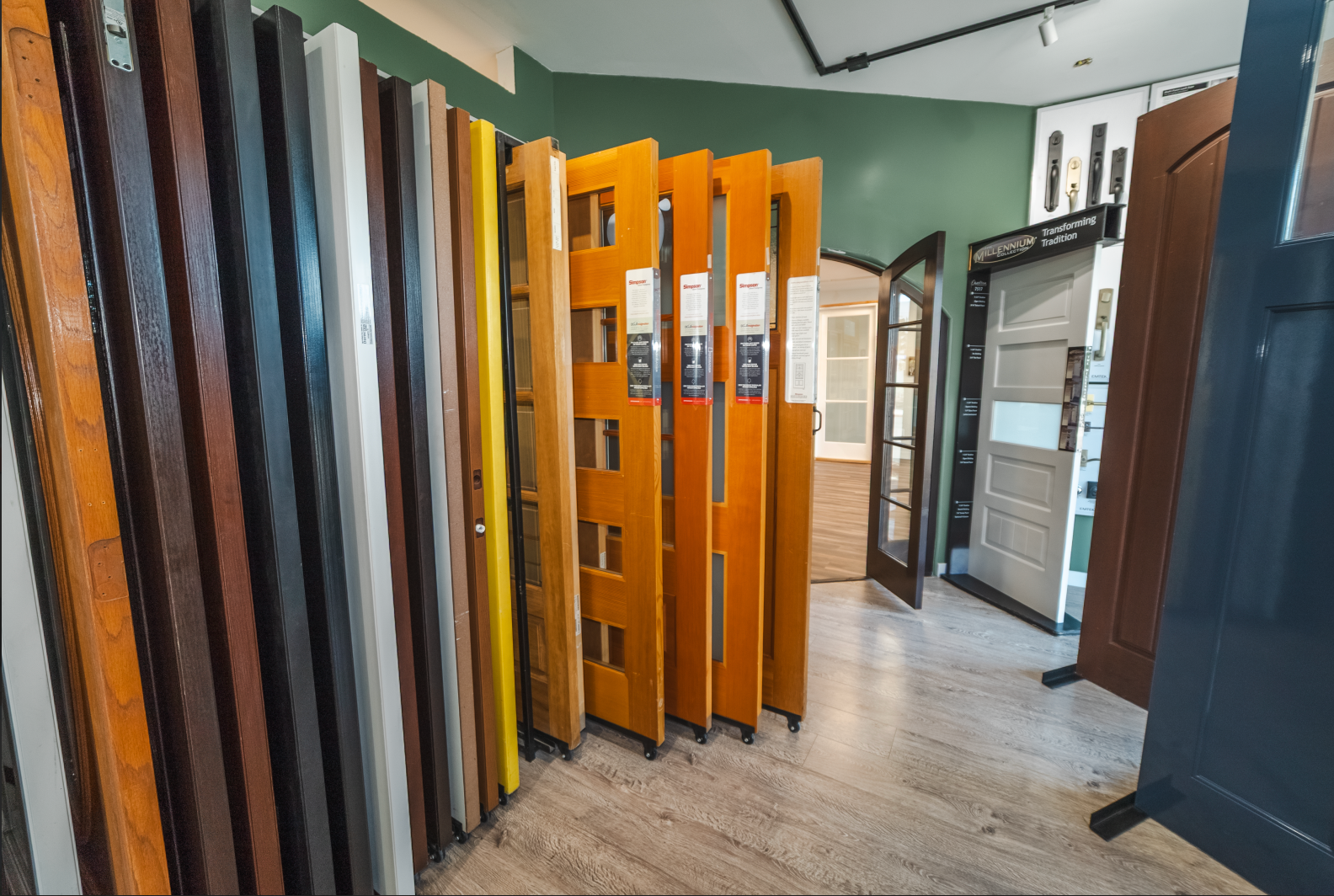 Door showroom with various wooden doors on display, showcasing different colors and styles.