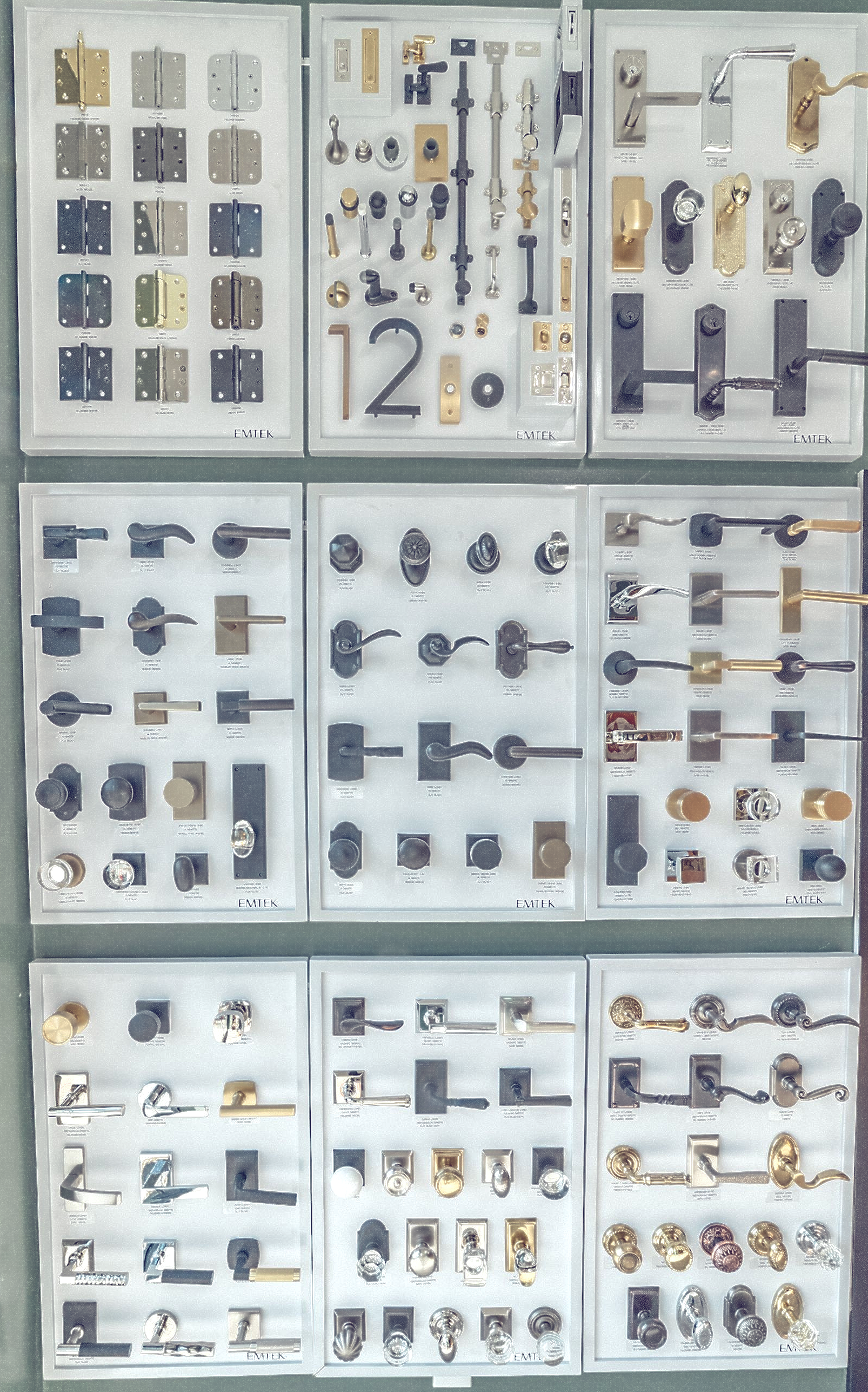 Display of various door hardware, including handles, locks, and hinges, arranged on panels.