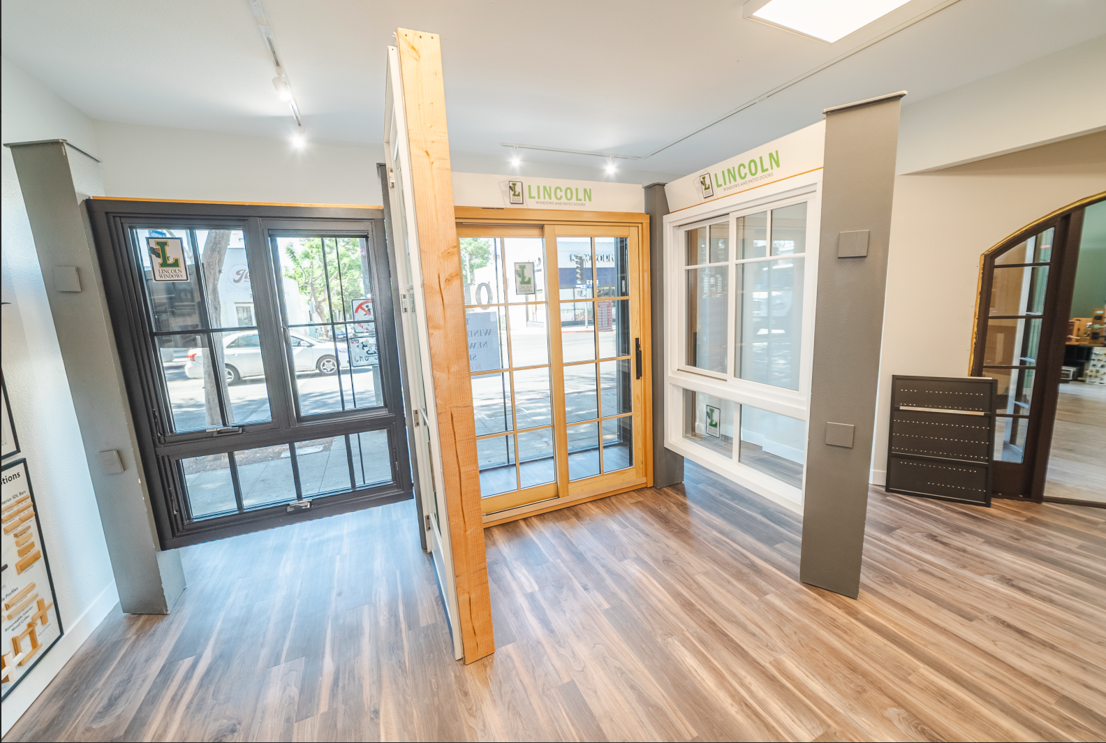 Interior showroom with window and door displays; wooden floors, bright lighting.