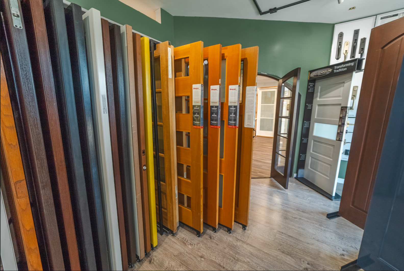 A showroom displaying various door styles and colors for sale; a mix of wood and painted doors.
