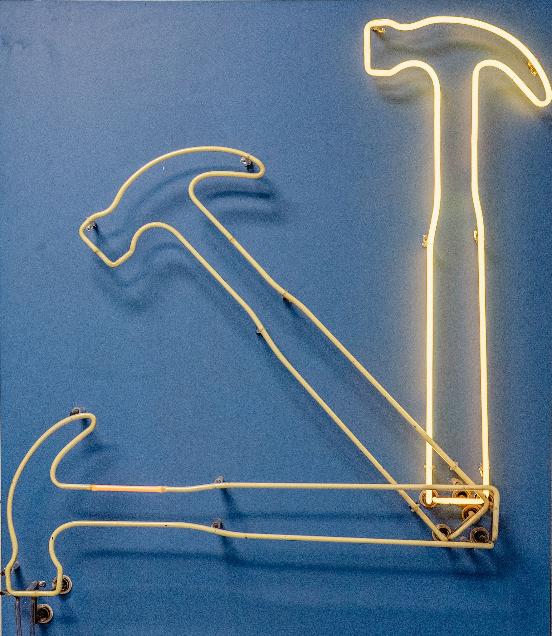 Three neon yellow hammer outlines on a blue background.