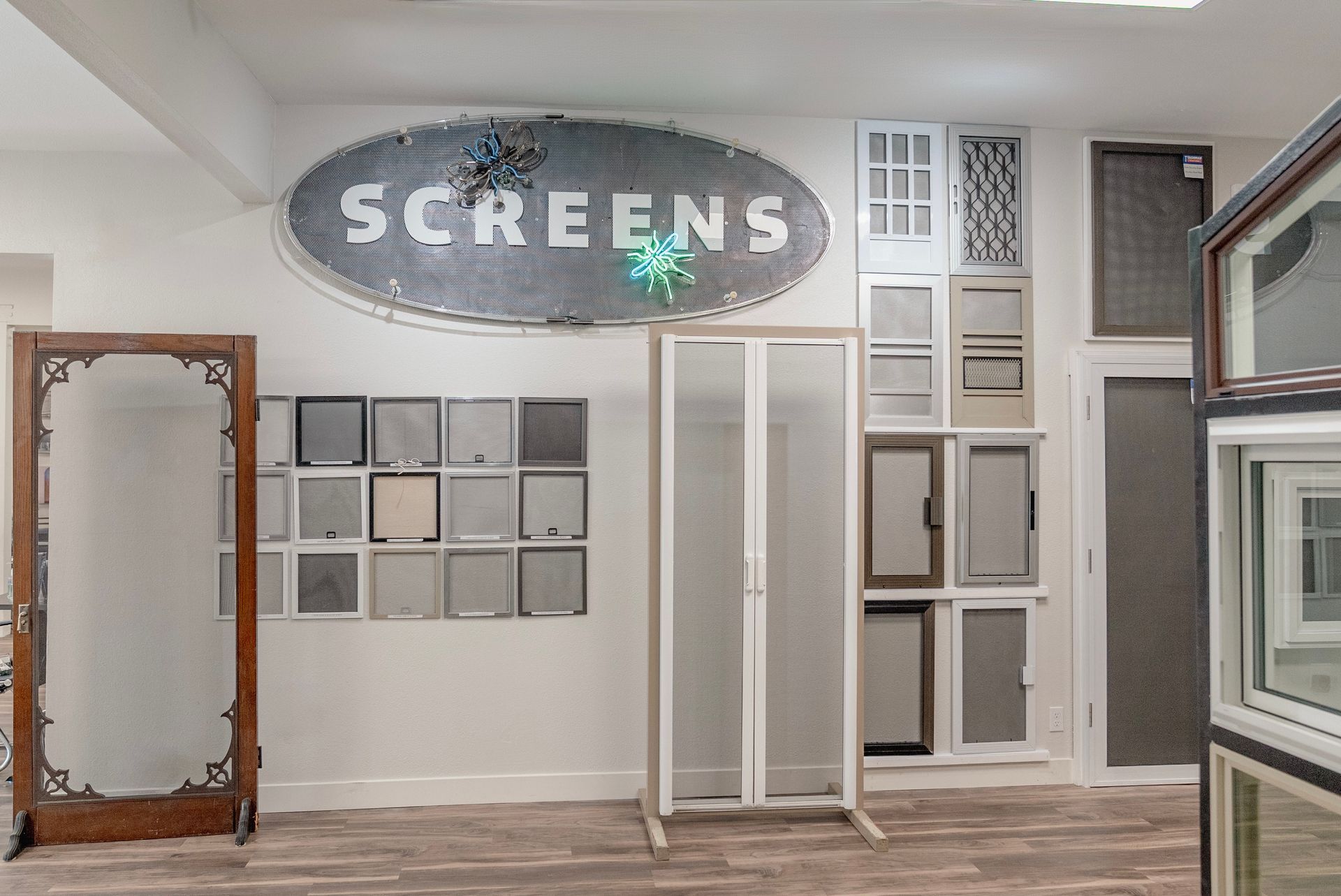 Interior of a screen store with various screen styles displayed on walls and floor. A