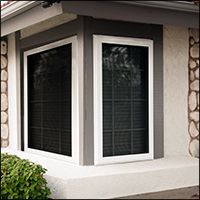 Bay window with white trim, gray border, and dark screens.