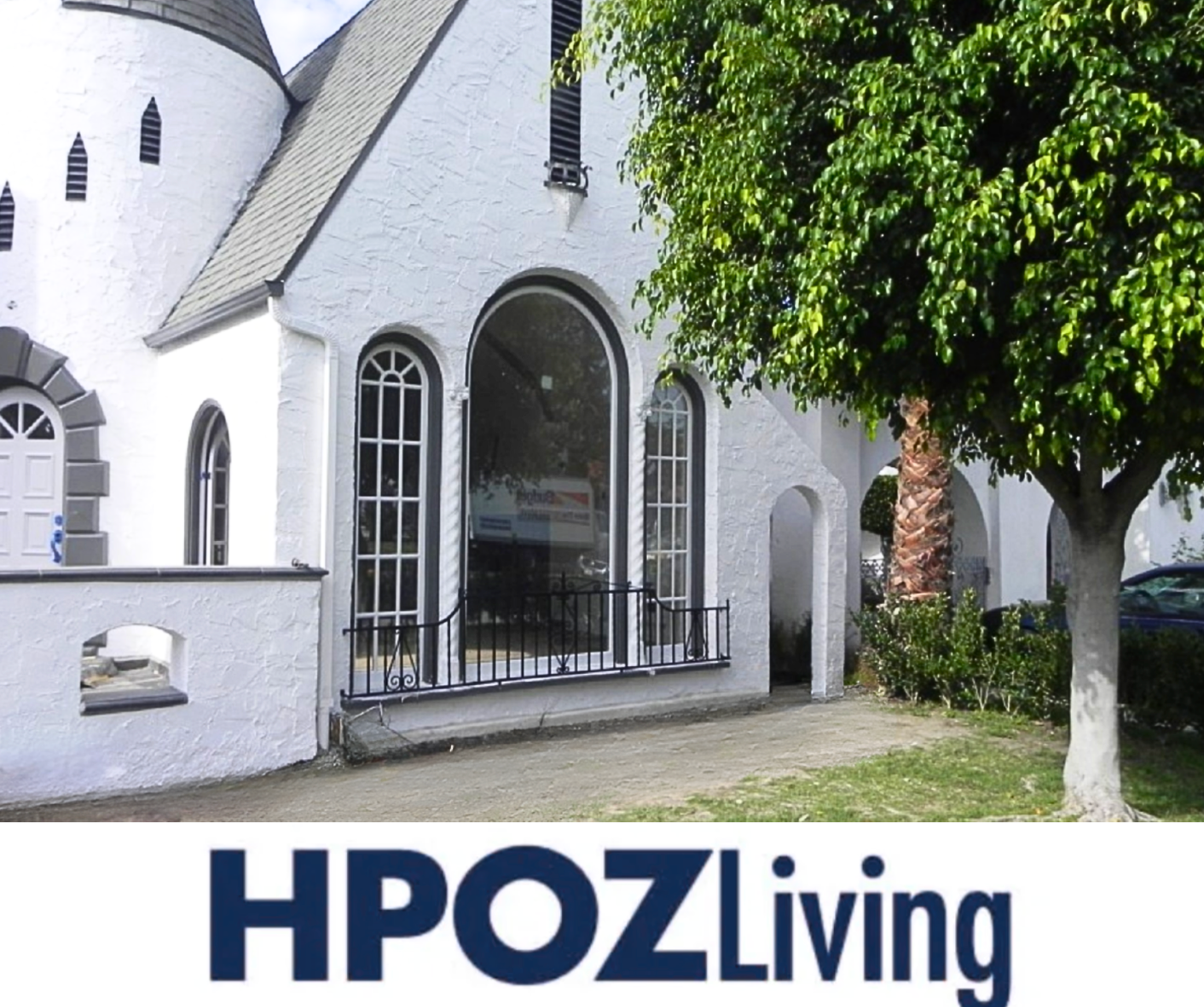 White building with arched windows and a tree;