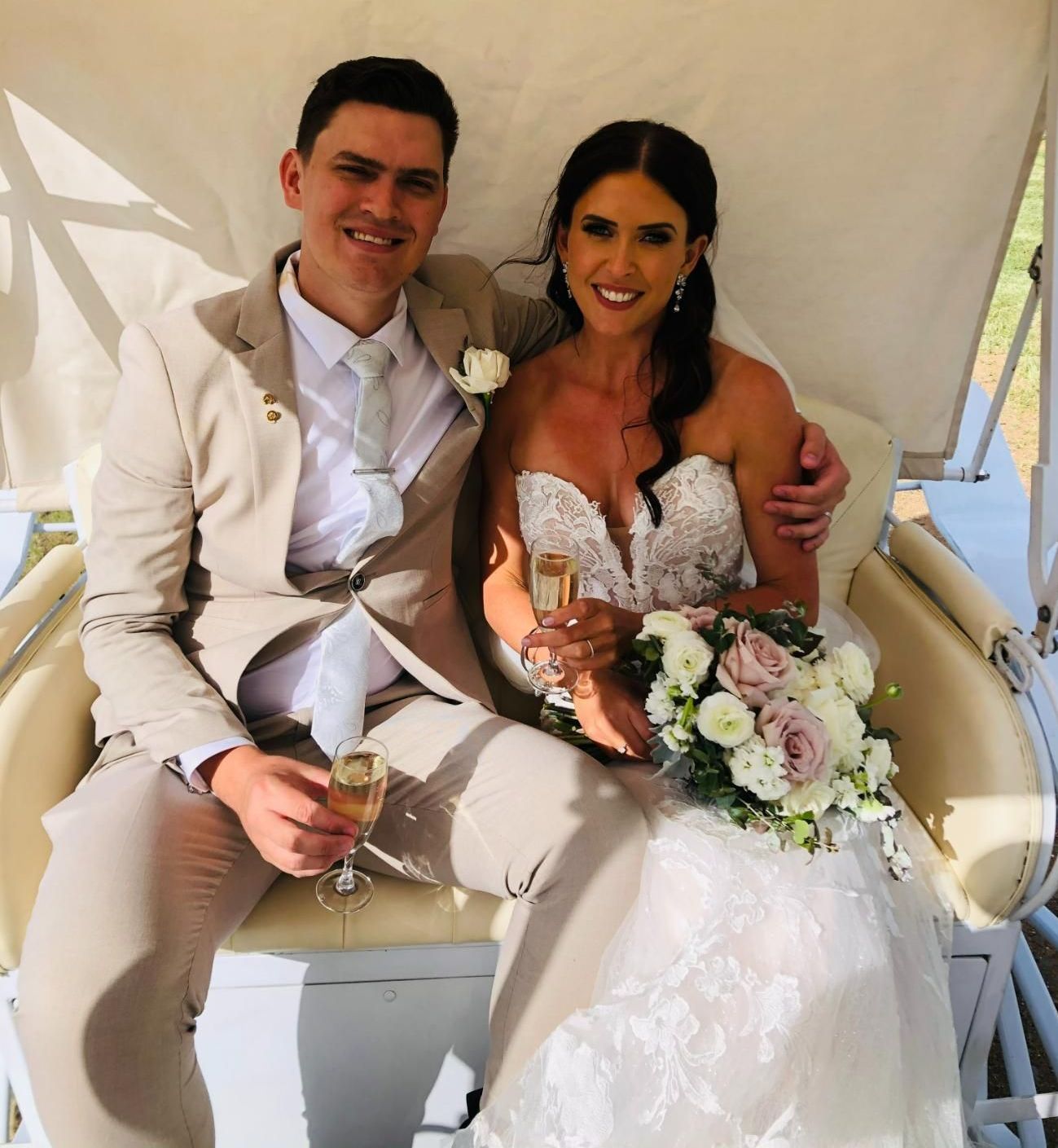 A Bride and Groom Are Sitting in a Carriage Holding Champagne Glasses — Prestige Horse Carriages in Newcastle, NSW