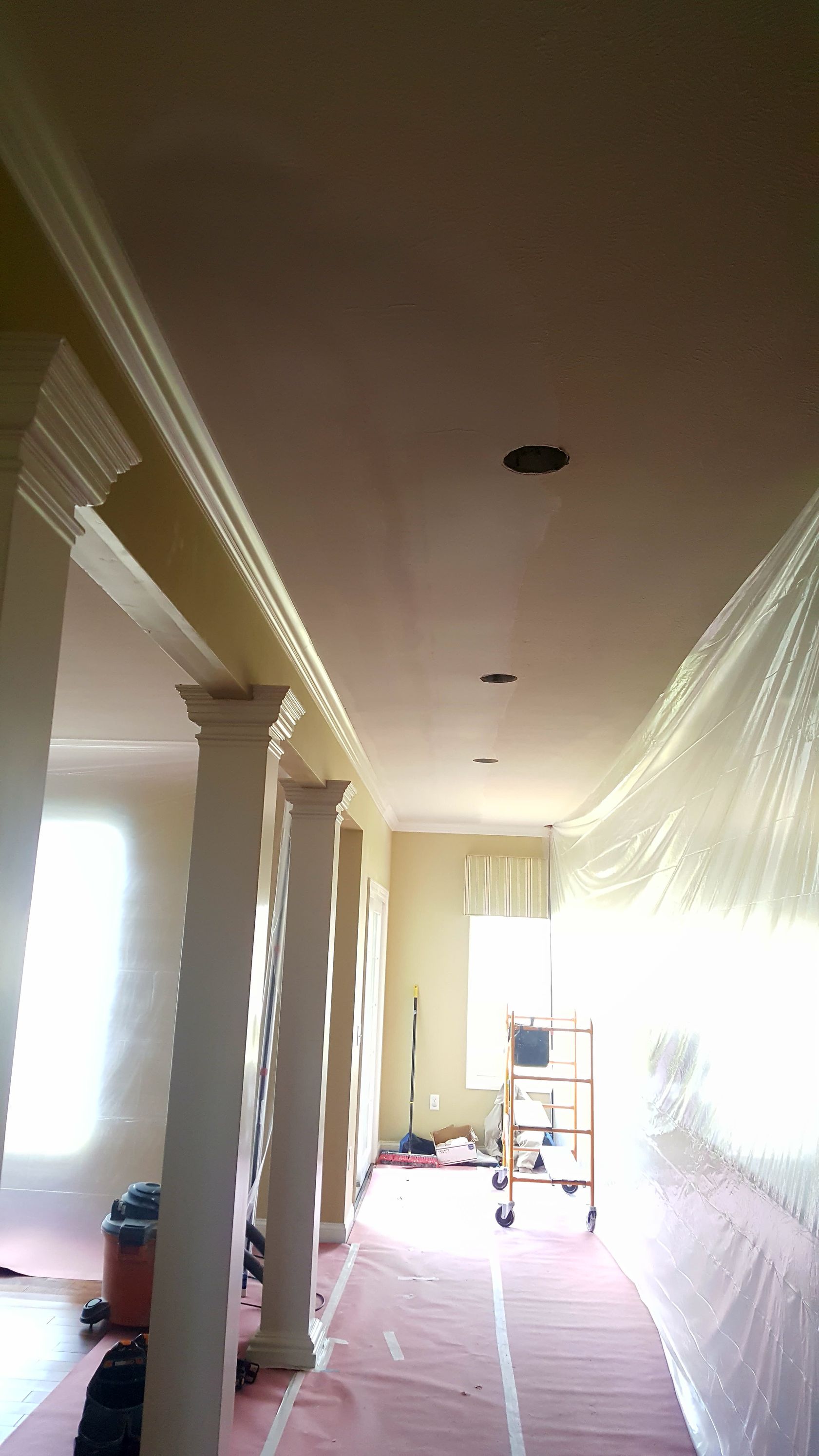 A hallway in a house that is being painted.