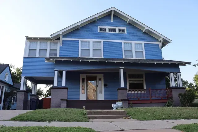 A blue house with white trim and a porch
