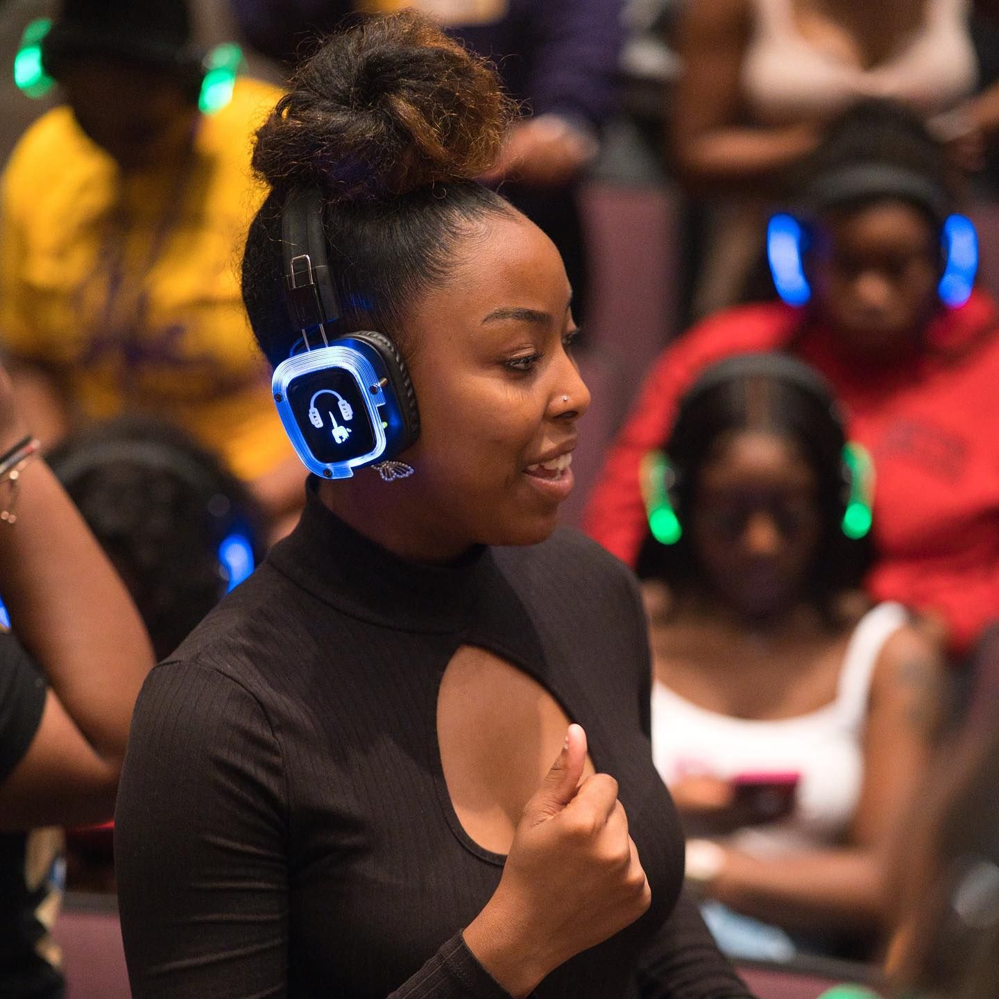 A woman wearing headphones with the letter c on them