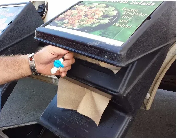 A person pulling a paper towel out of a container that says chicken salads