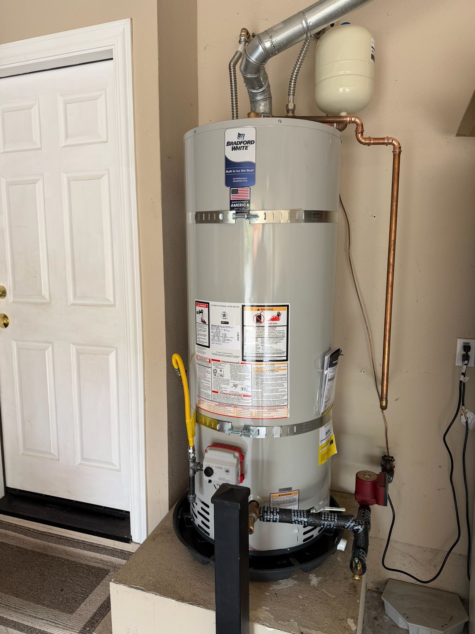 Water heater and furnace in a utility closet with exposed pipes and venting.