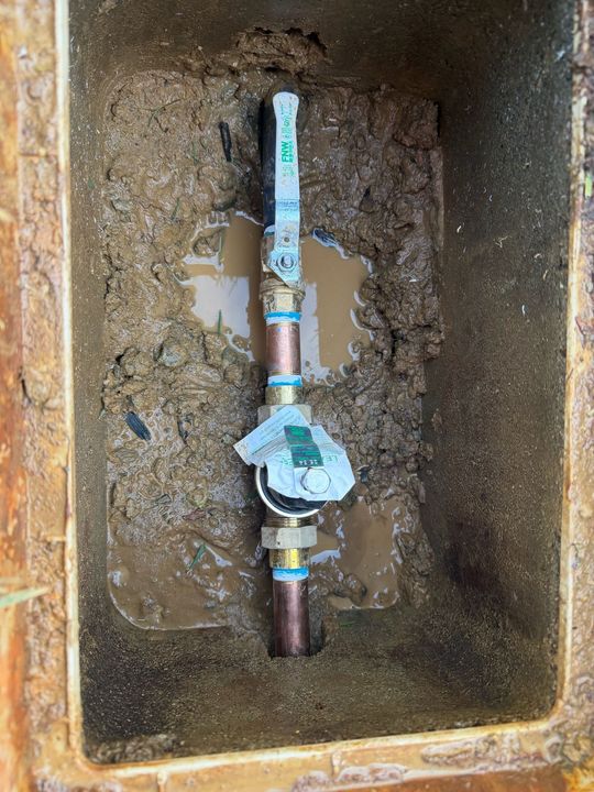 Plumbing pipes in attic. Copper and white pipes attached to wooden beams and insulation.