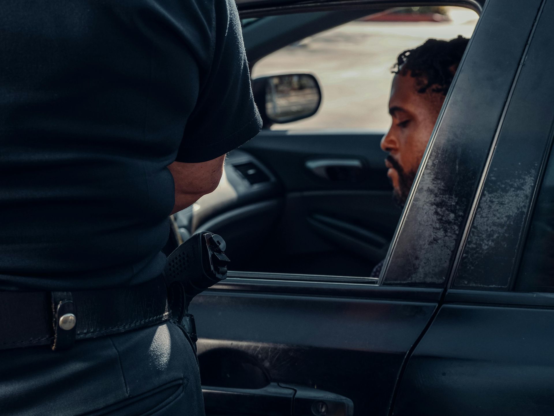 Police officer speaking to a driver through a car window at a traffic stop