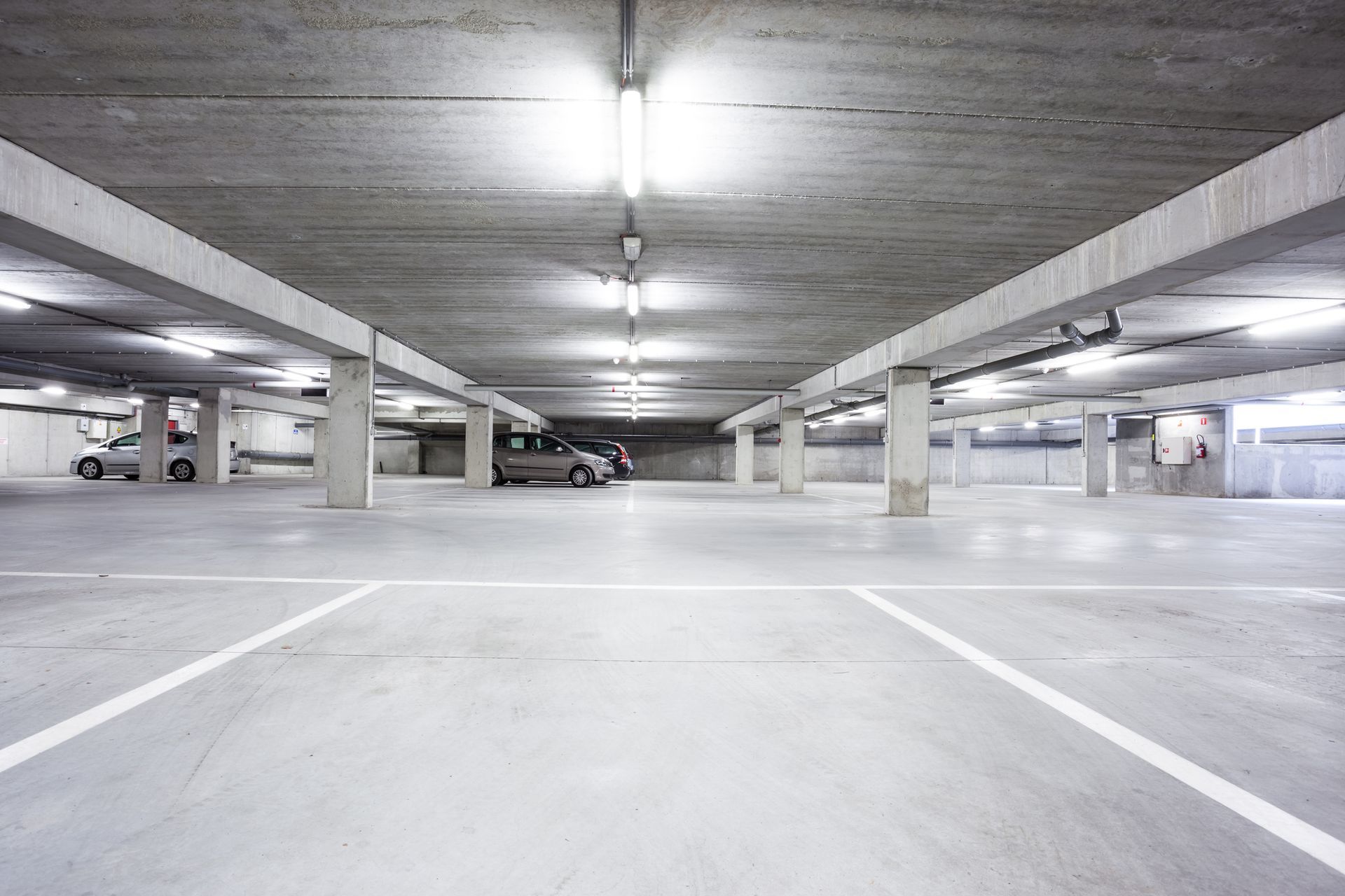 An empty parking garage with cars parked in it.