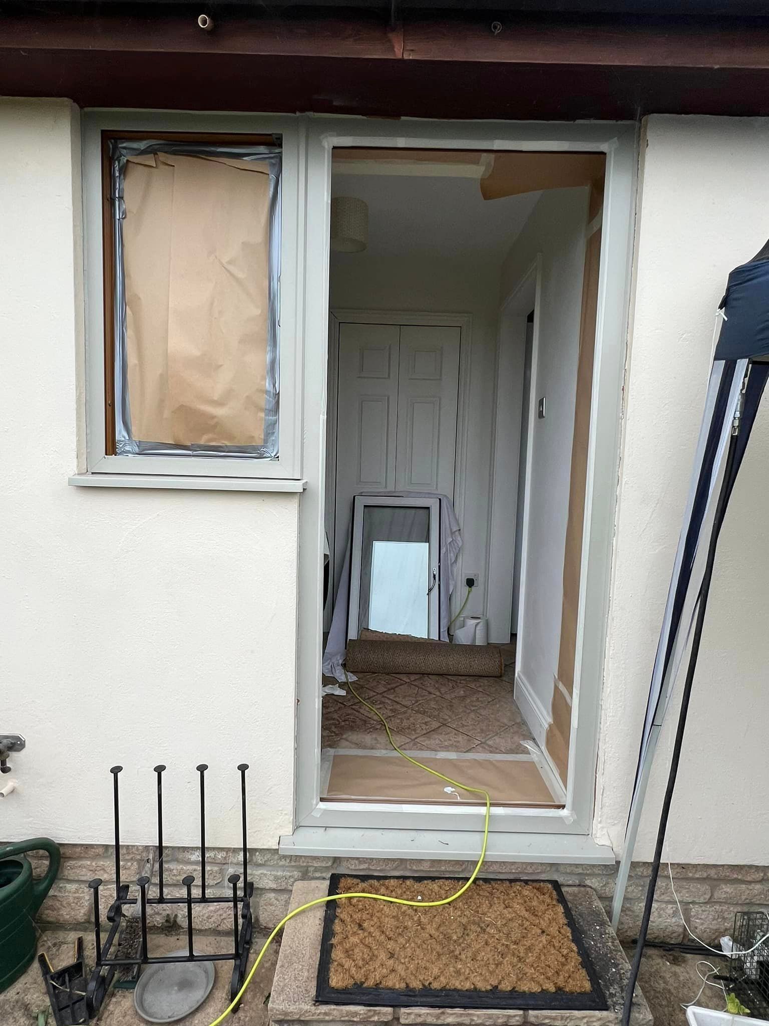 A white house with a broken window and door.