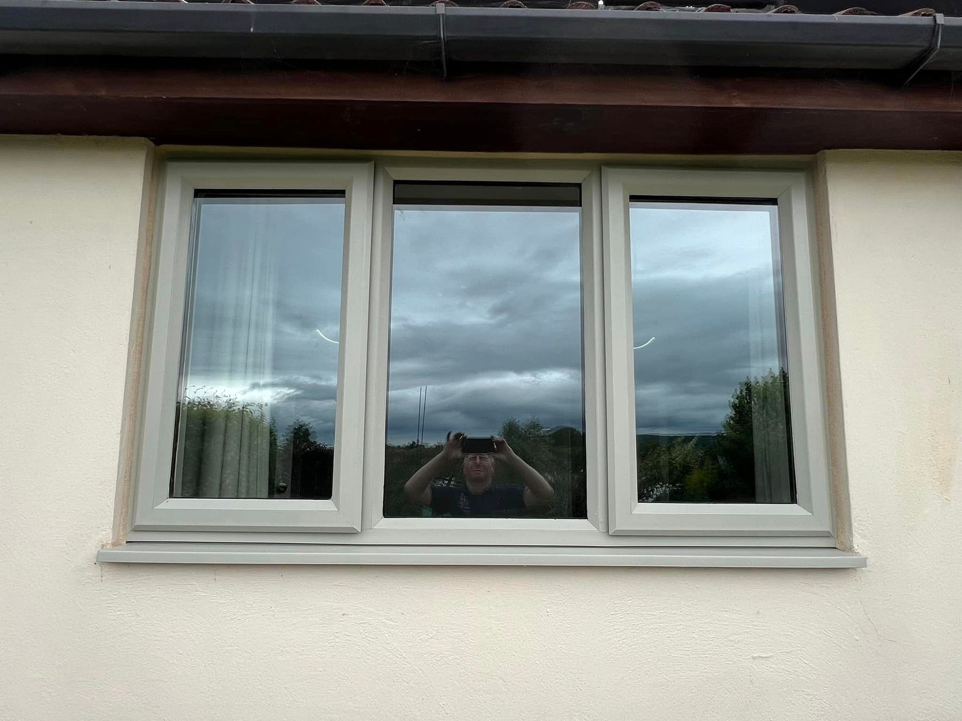 A man is taking a picture of himself in a window.