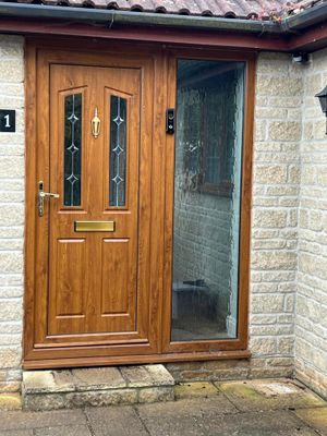 The front door of a house with a wooden door and a glass door.