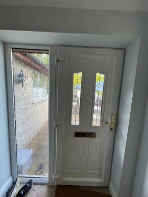 A white door with a window in a hallway.
