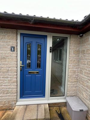 A blue door is on the side of a brick house.
