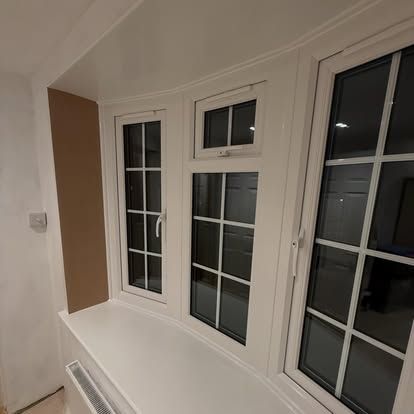 Interior bay window with white-framed panes and a radiator below