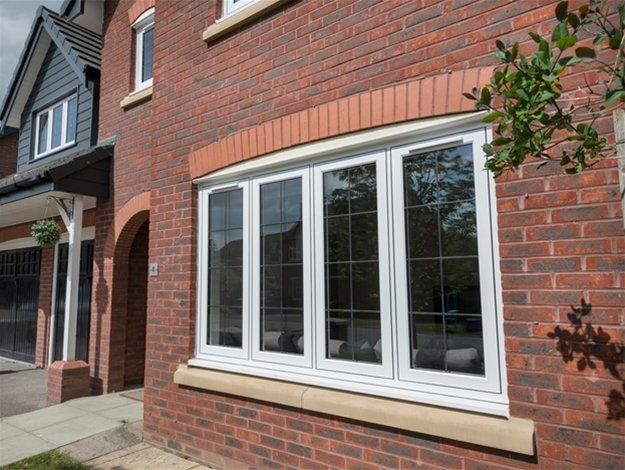 Brick house exterior with white bay window and front porch detail
