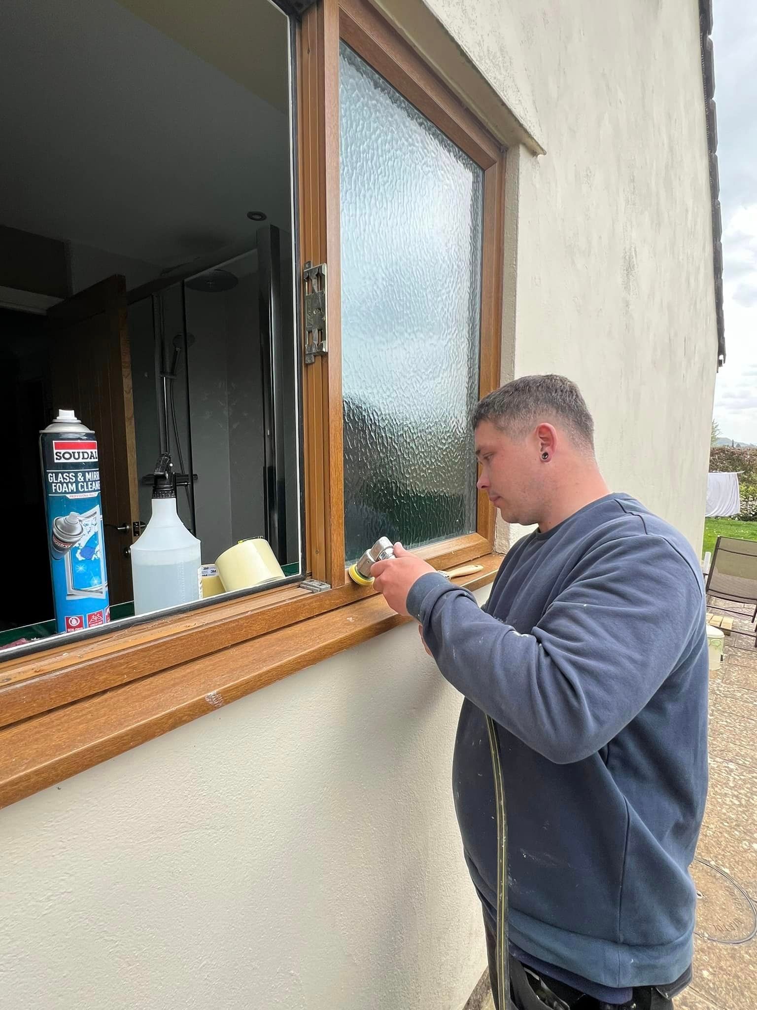 A man is fixing a window on a house.