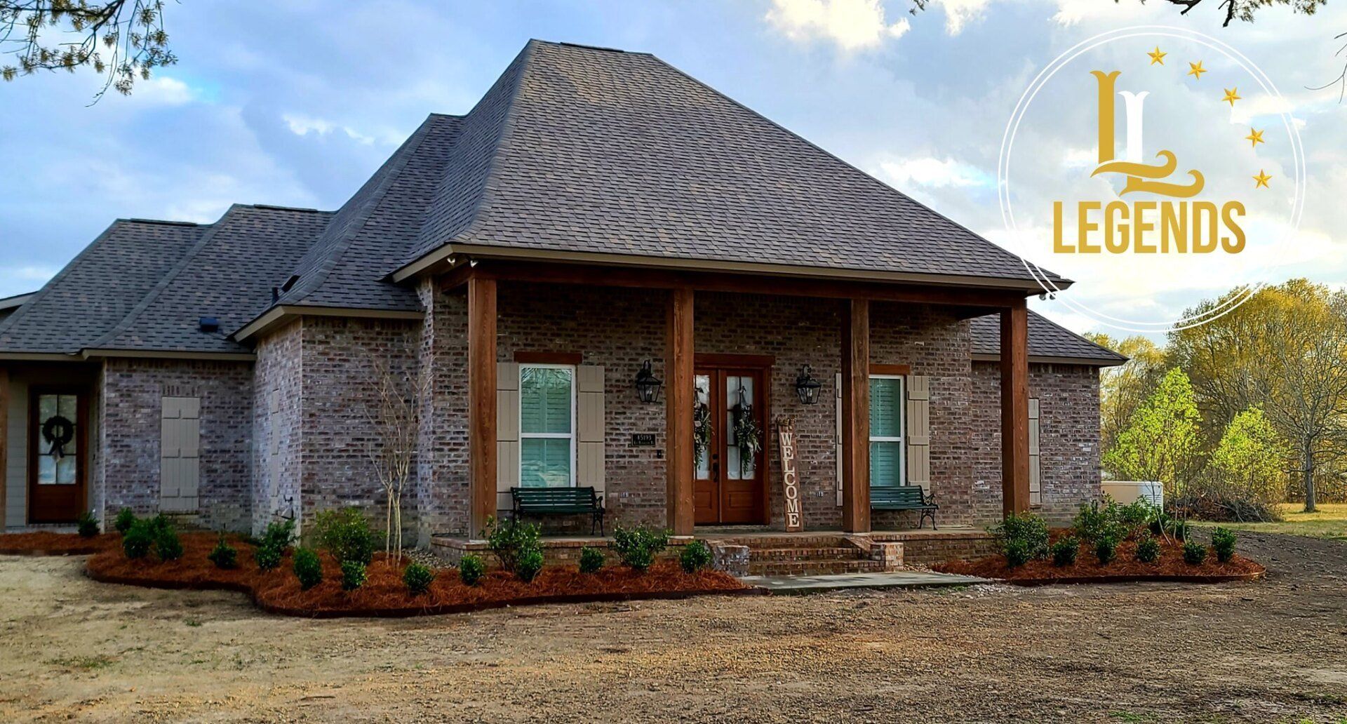 A large brick house with a porch and a logo that says legends