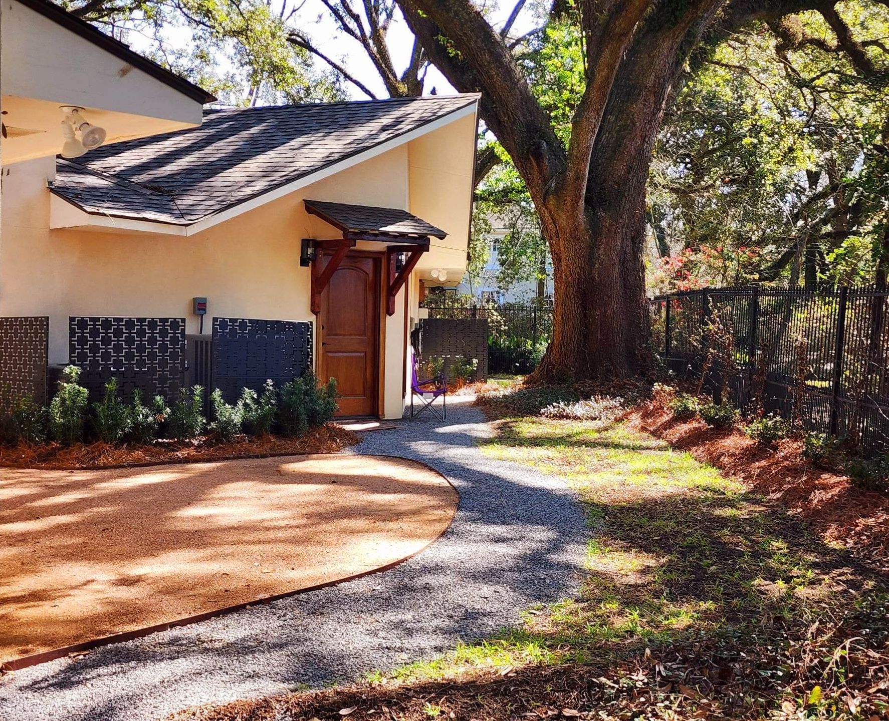 A driveway leading to a house with trees in the background