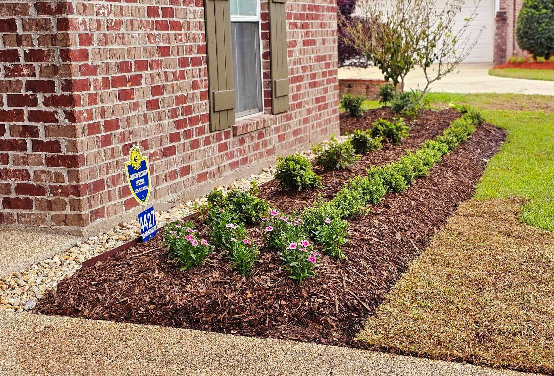 A brick house with a garden in front of it