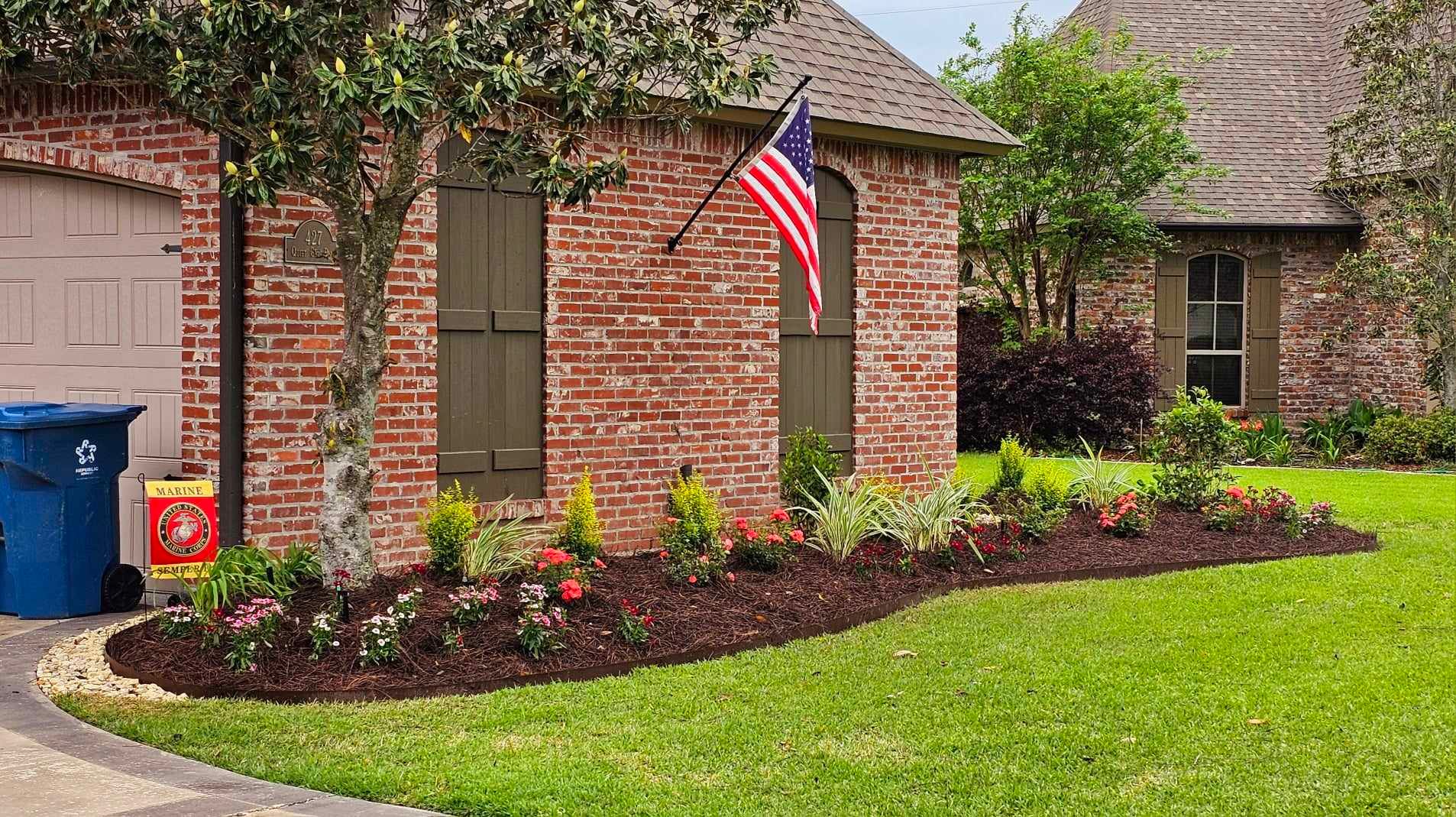 A brick house with a flag hanging from the side of it.