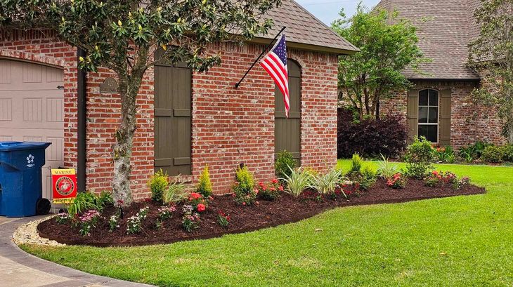 A brick house with a flag hanging from the side of it.