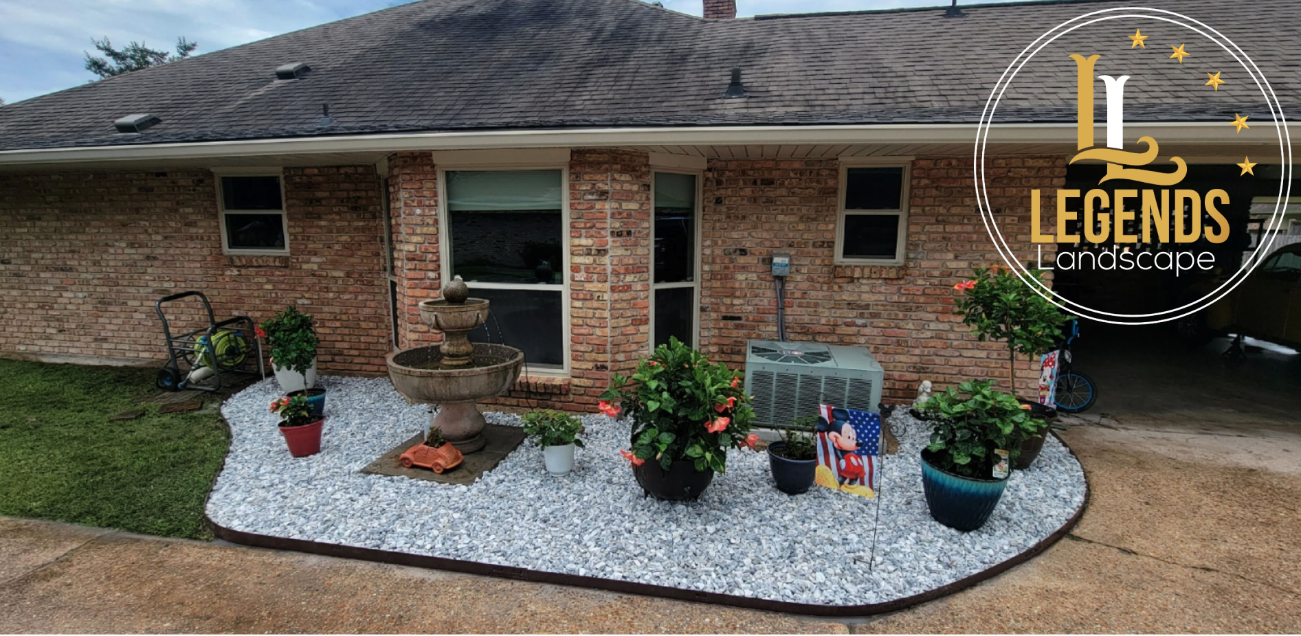 A brick house with a gravel garden in front of it