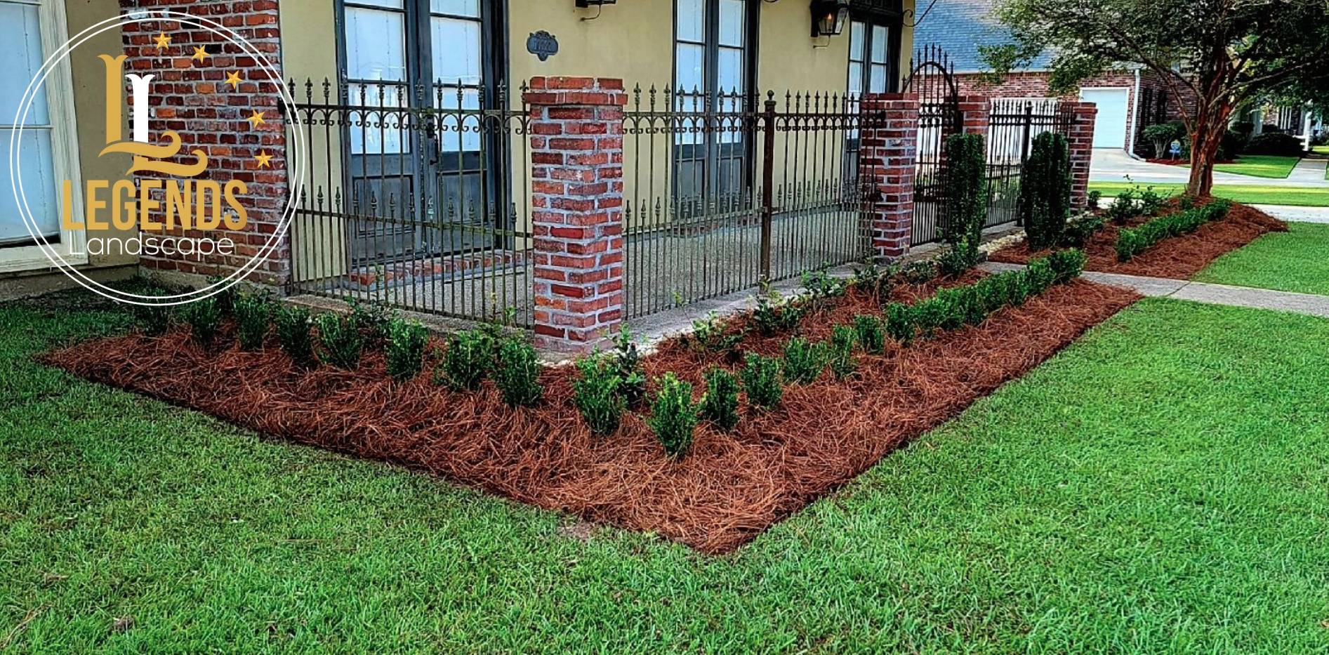 A house with a lush green lawn and a brick fence.