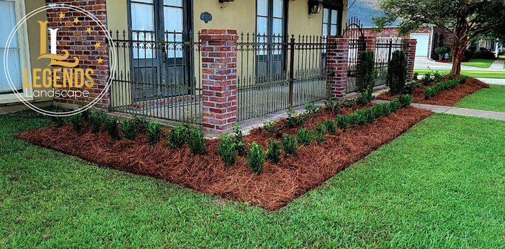 A house with a lush green lawn and a brick fence.