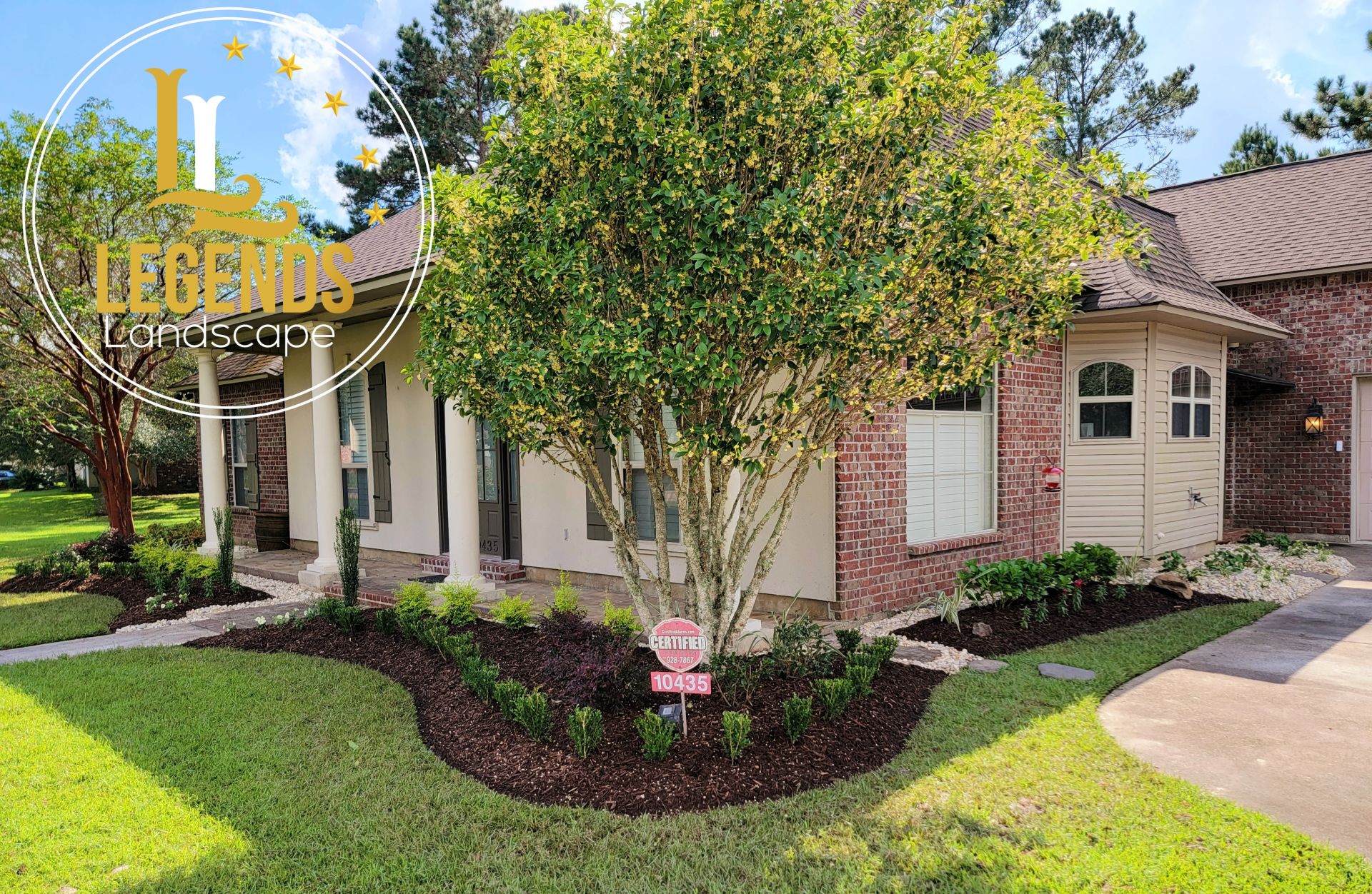 A large brick house with a large tree in front of it.