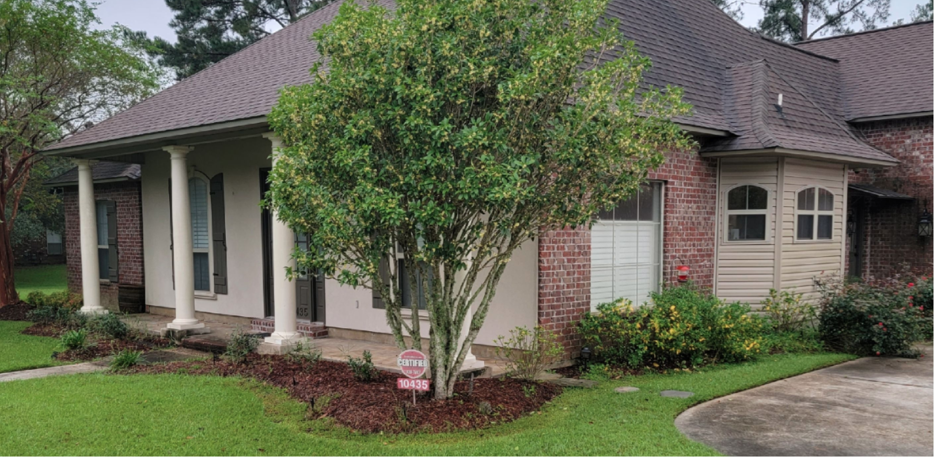 A house with a for sale sign in front of it.