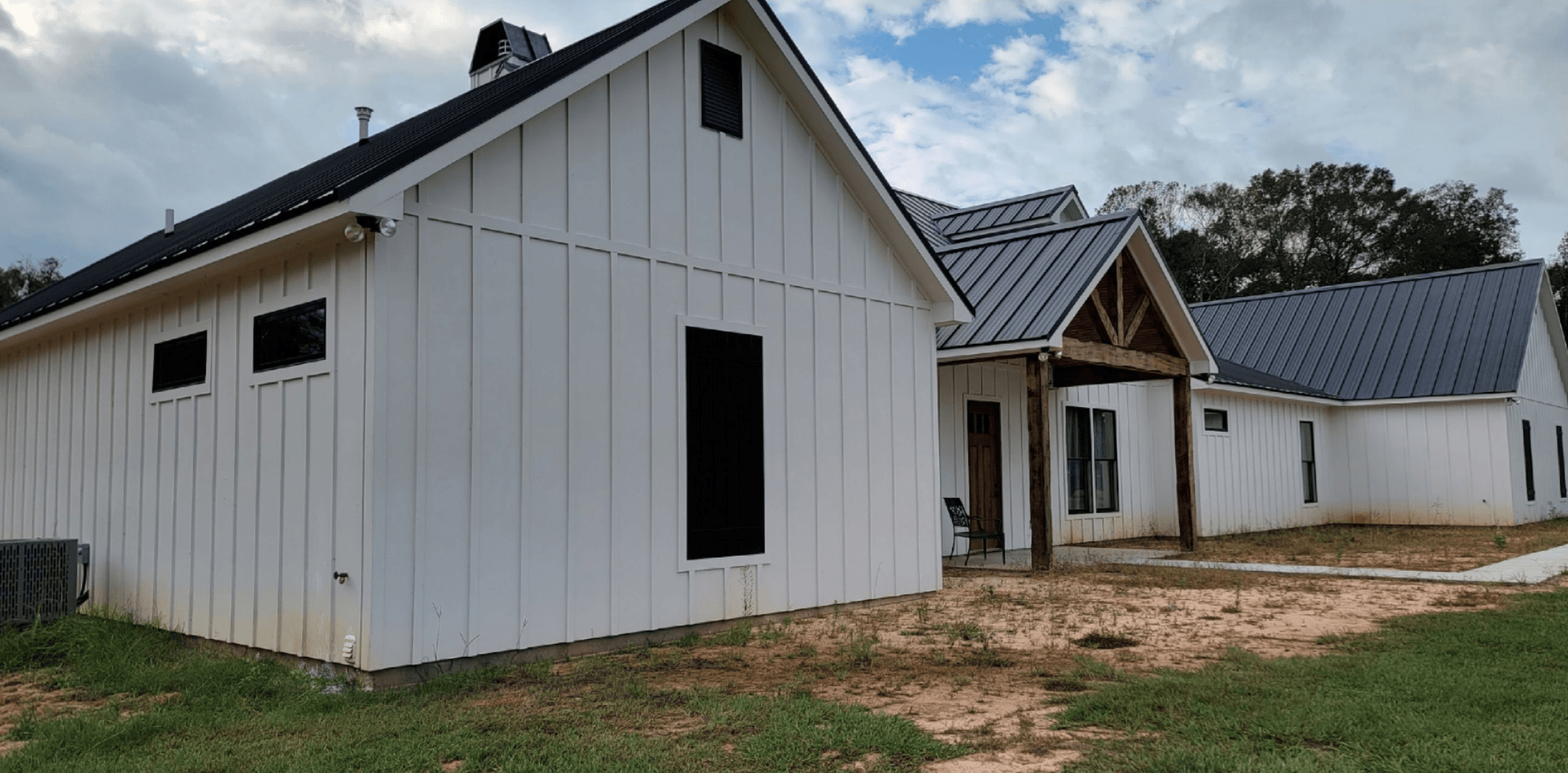 A large white house with a metal roof is being built.