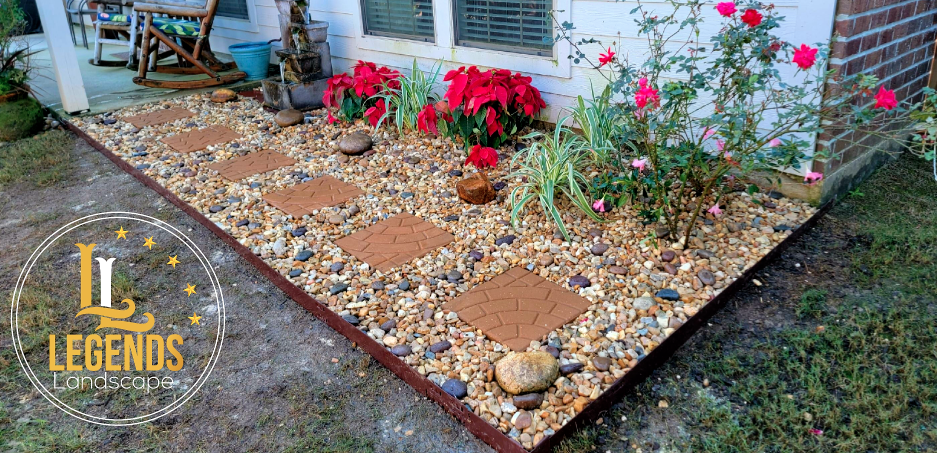 A walkway surrounded by rocks and flowers in front of a house.