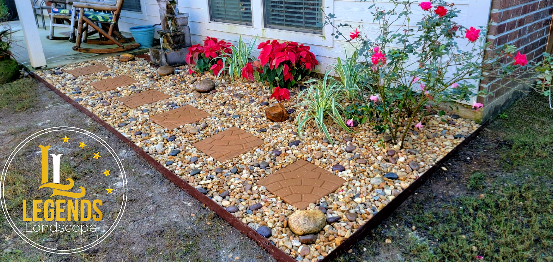 A garden with flowers and rocks in front of a house.