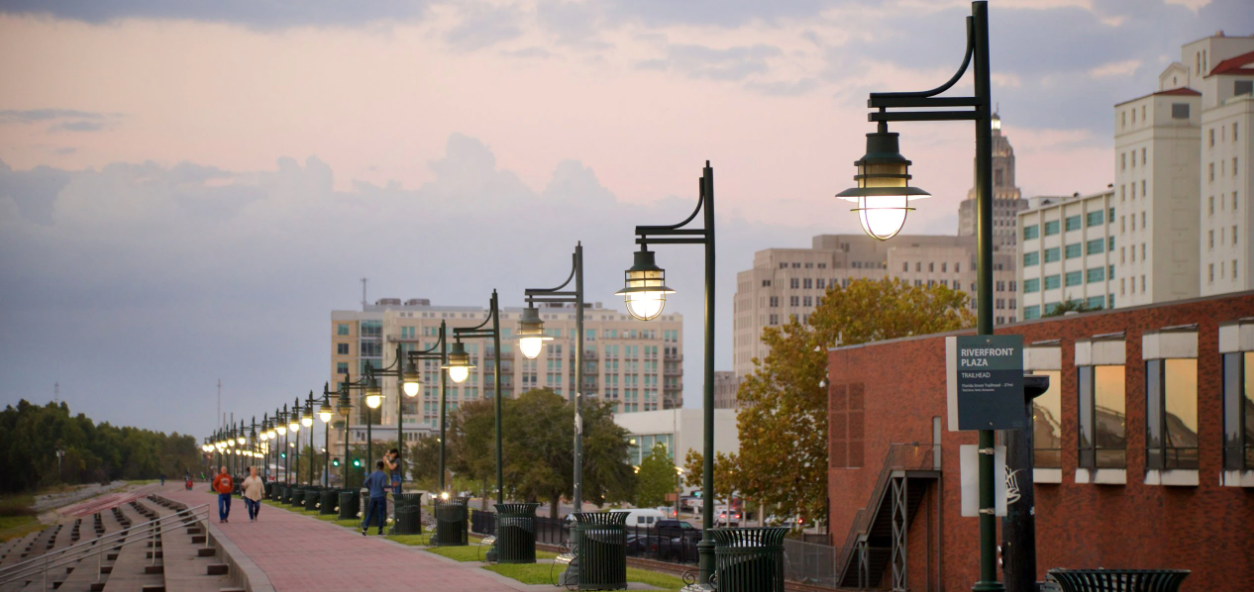 A row of street lights along a sidewalk in a city