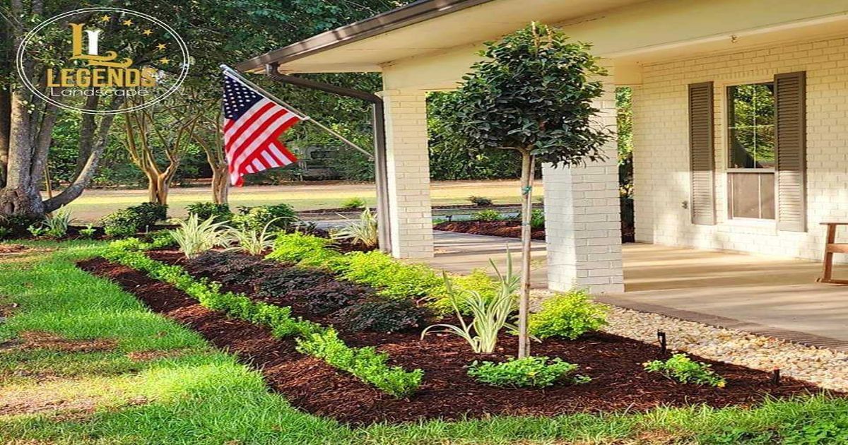 A large american flag is flying in front of a house.