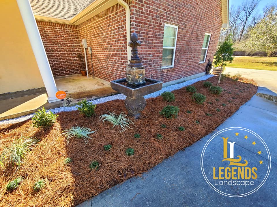 A brick house with a fountain in front of it.