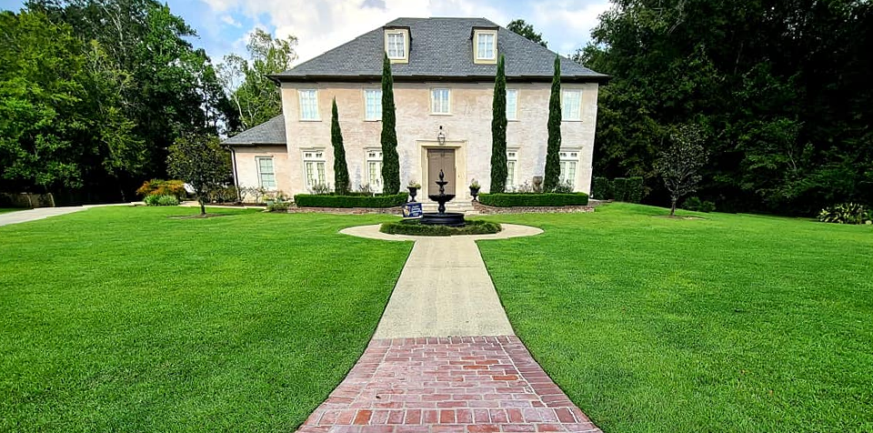 A large house with a brick walkway leading to it