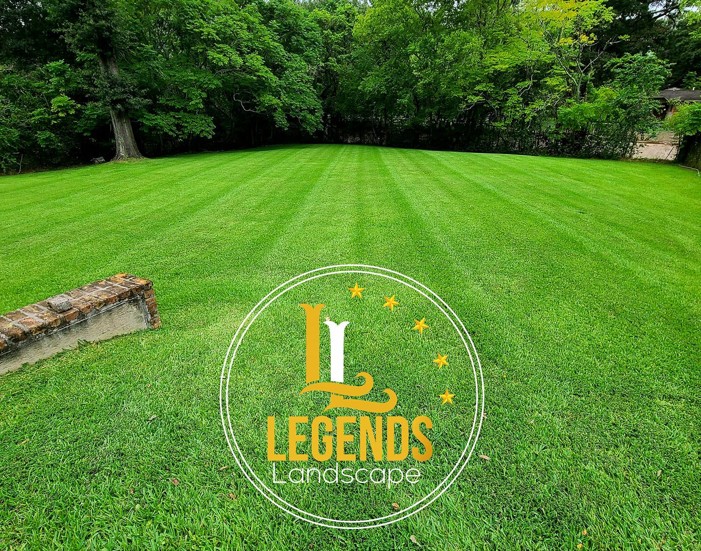 A lush green lawn with trees in the background and a logo for legends landscaping.