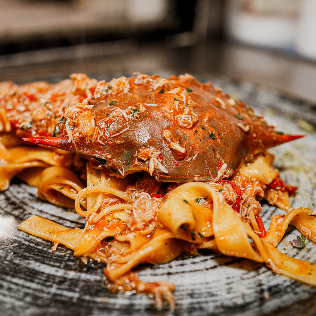 Pâtes au crabe et sauce tomate ; gros plan sur une assiette grise.